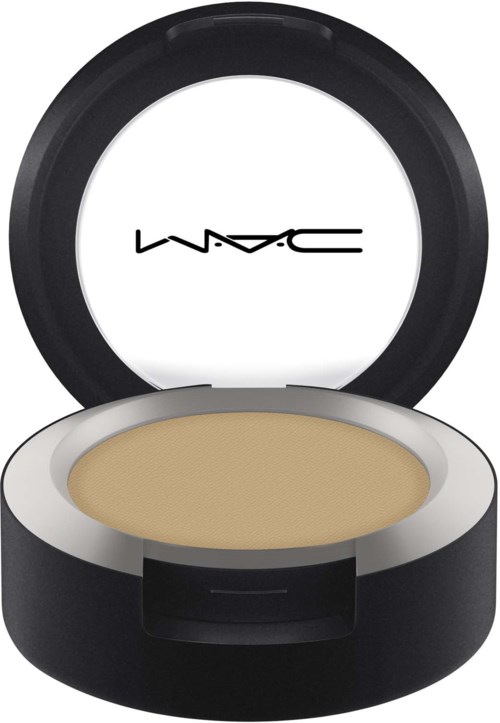 En rund behållare med beige makeup inuti och ett lock med MAC-loggan, svart på utsidan och vitt inuti.