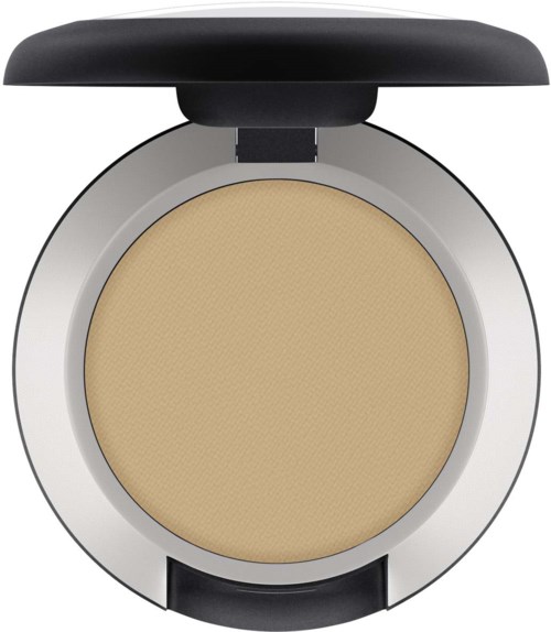 En rund puderccinkel med beige puder inuti, silverkant, och svart lock öppet.