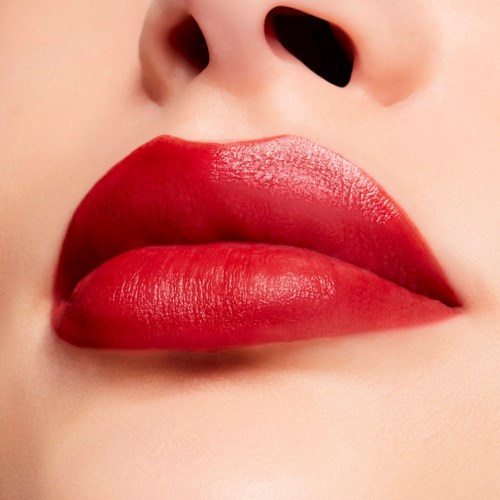 Close-up of lips with bright red lipstick and skin color visible near the nose.