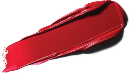 A bold red lipstick smear on white surface, showing shiny, creamy texture and curved shape.
