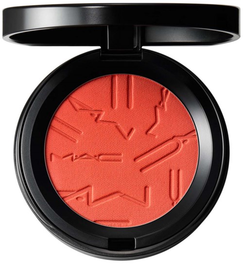 A round compact with bright red blush embossed with abstract lines, inside a black case with a lid.