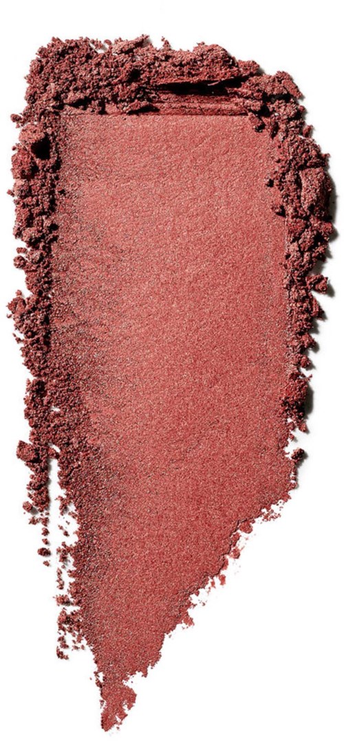 A pinkish red makeup blush with a rough edge, spread unevenly on a surface.