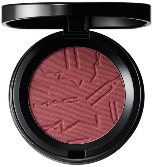 A round makeup blush in a black compact with a geometric pattern design engraved on it.
