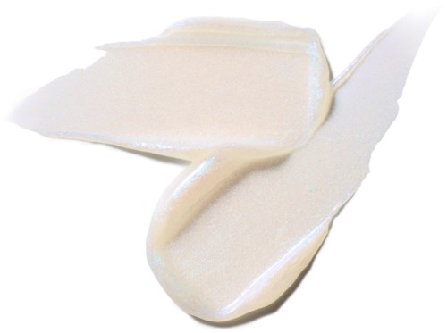 A spoon is scooping and spreading white creamy substance on a black surface.