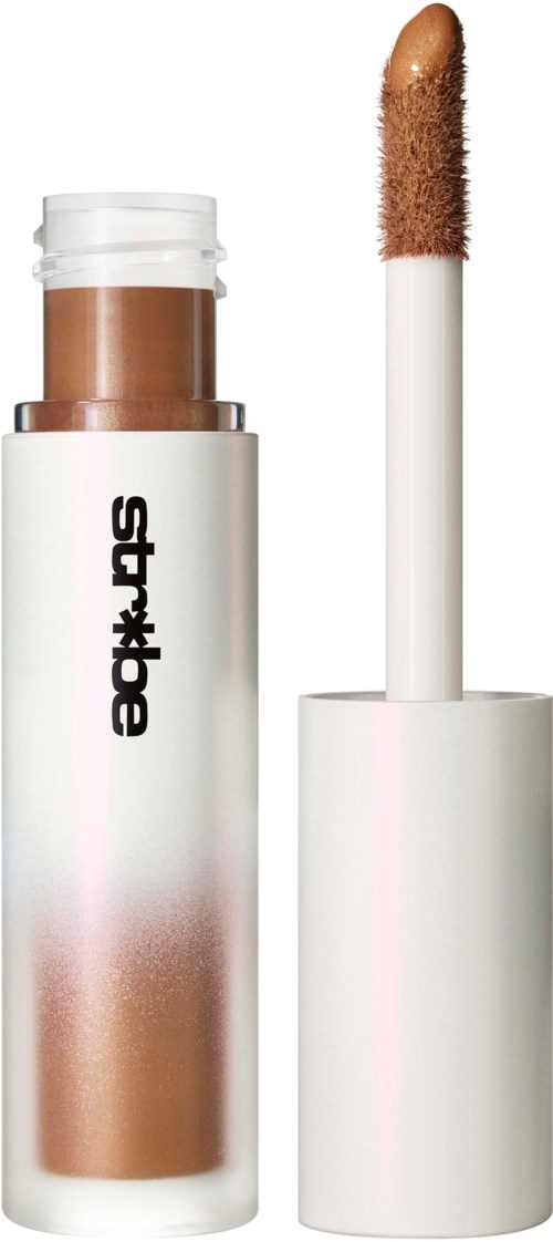 A makeup concealer stick with a white cap and brownish liquid inside. The applicator is separate from the tube.
