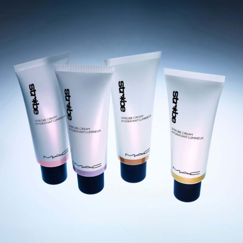 Four tubes of MAC Studio Fix Strobe Cream in different shades standing upright on a light blue background.