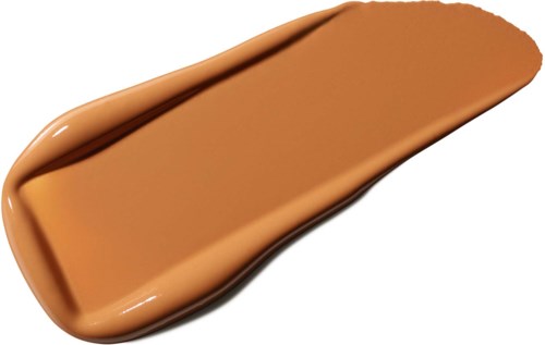 En prøve av beige flytende foundation spredt på en overflate, viser jevn tekstur og god dekking.
