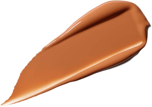 Kremaktig beige foundationprøve på hvit bakgrunn.