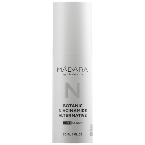 A white bottle of skincare serum labeled 'MÁDARA,' with product details about botanical niacinamide, suitable for skincare.