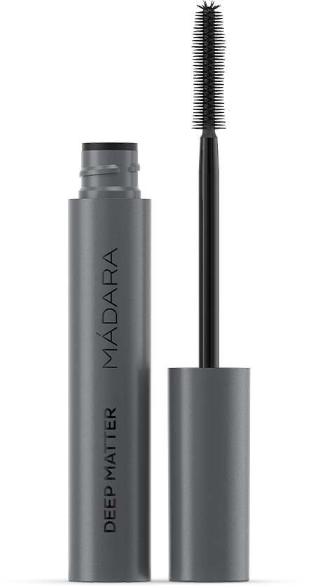Een grijze mascara-tube met een zwarte borstelspons ernaast, gemerkt "MADARA DEEP MATTER."