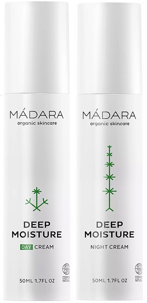 Kaksi valkoista pulloa, merkitty Mádara Deep Moisture Day ja Night Cream, vihreitä kasvi-symbolien kanssa, tarkoittaen ihonhoitotuotteita.