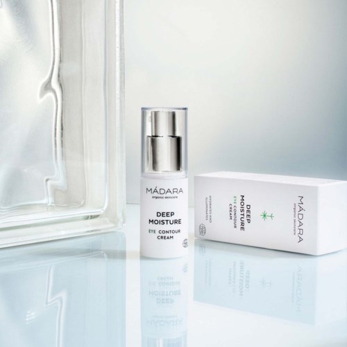 A skincare product named Madara Deep Moisture Eye Contour Cream with its box, placed on a light surface.