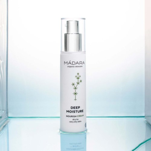 En vit flaska med pump som heter 'MADARA deep moisture nourish cream' för mycket torr hud.