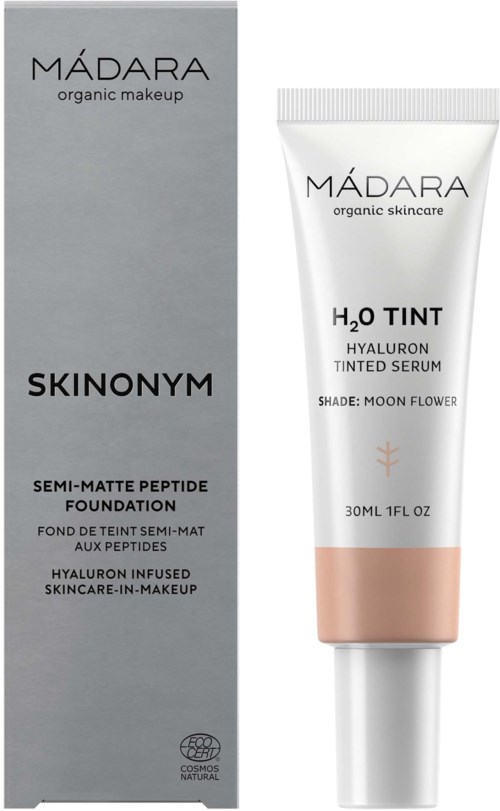 A tube of MÁDARA tinted serum next to its box, labeled as skin care with hyaluronic acid and moon flower shade.