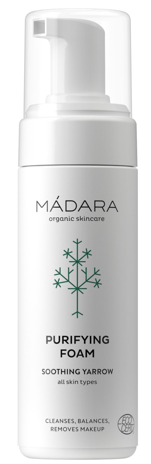 A white bottle with a pump, labeled 'MÁDARA Purifying Foam,' featuring a snowflake design. It is for skin cleansing.