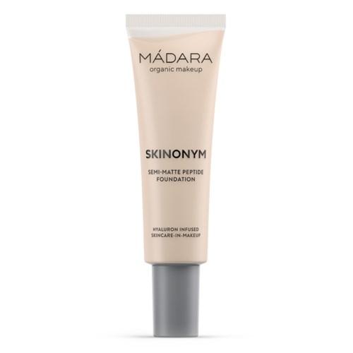 A beige tube of Madara organic makeup with gray cap, labeled 'Skinonym' semi-matte foundation, contains hyaluronic acid.