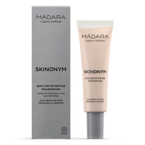 A cosmetic product tube and box, labeled MÁDARA and SKINONYM, describe a semi-matte foundation with hyaluronic acid.