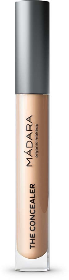 A beige concealer in a clear tube with a silver cap. The text on the tube says "MÁDARA," "The Concealer," and "Professional Makeup."