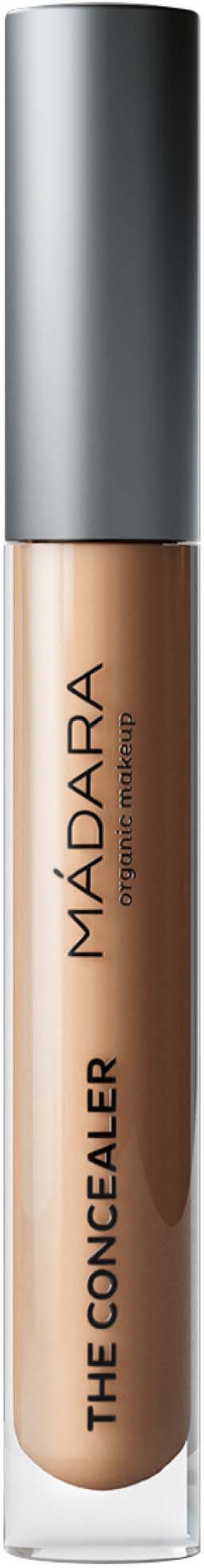 A concealer tube with a silver cap and beige liquid inside, labeled 'The Concealer' by MÁDARA.