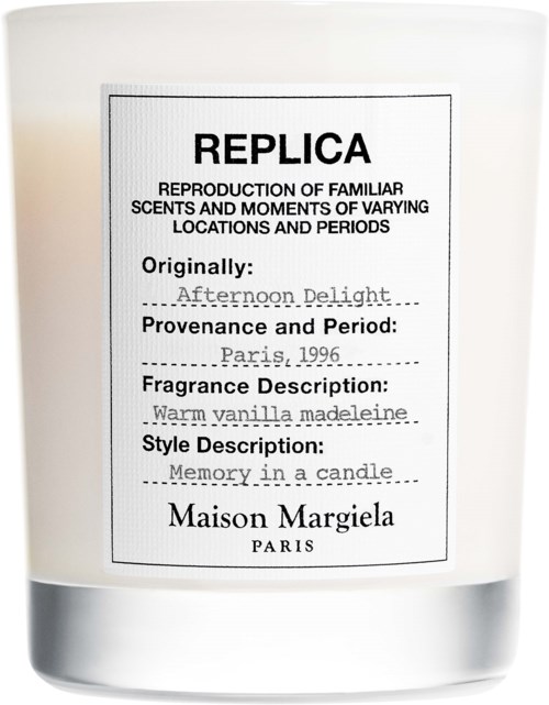 Ein weißer Kerze mit einem Etikett, das angibt, dass es sich um eine Nachbildung eines warmen Vanilleparfüms aus Paris von Maison Margiela handelt.