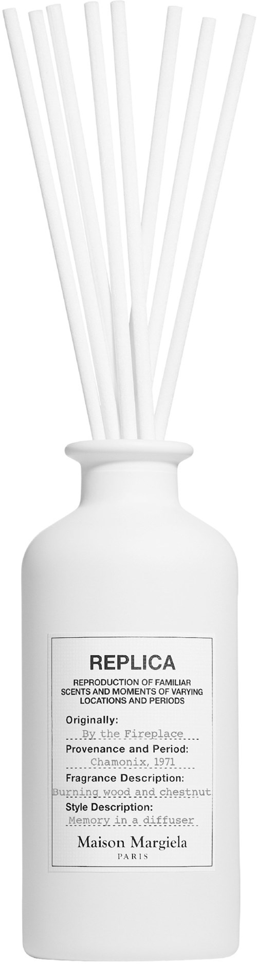 Eine weiße Duftdiffusorflasche mit Schilfrohren und einem Etikett mit Text, einschließlich Marke und Duftdetails.