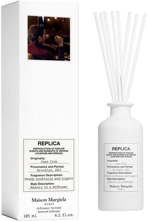 Eine weiße Box und eine weiße Flasche, beide mit 'Replica' beschriftet, scheinen Teil eines Parfümsets zu sein.