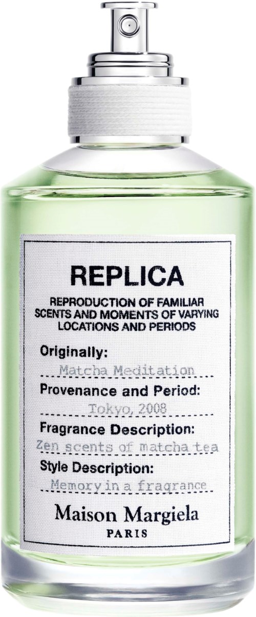 En tydlig parfyllare med spraymunstycke, märkt 'REPLICA' och 'Maison Margiela Paris', som innehåller en grön vätska.