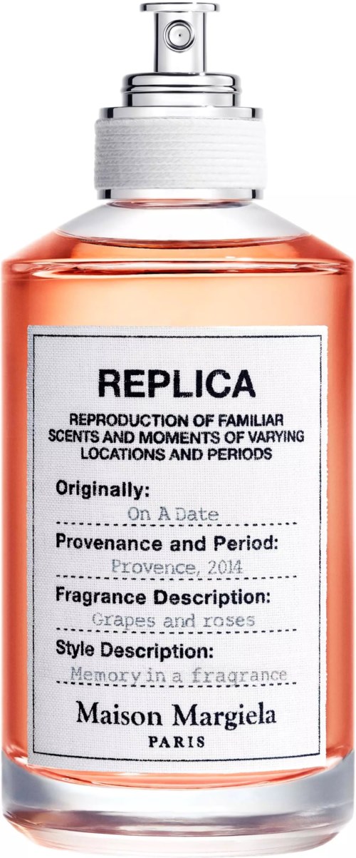 Een parfumfles met wit label, zwarte tekst en een zilveren spraydop. De vloeistof binnen is roze.
