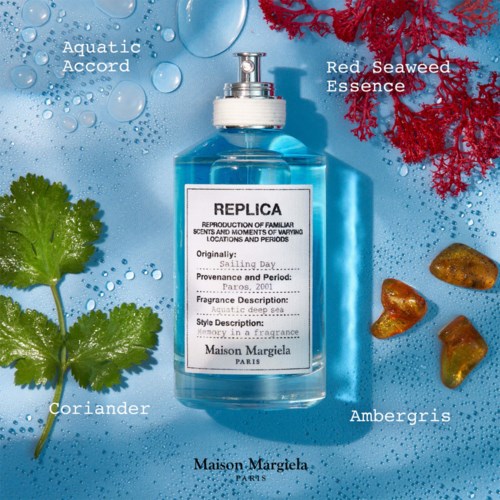 Eine blaue Parfüfflasche mit Maison Margiela auf dem Etikett umgeben von Seetang, Koriander, Ambergris und Wassertropfen auf blauem Hintergrund.