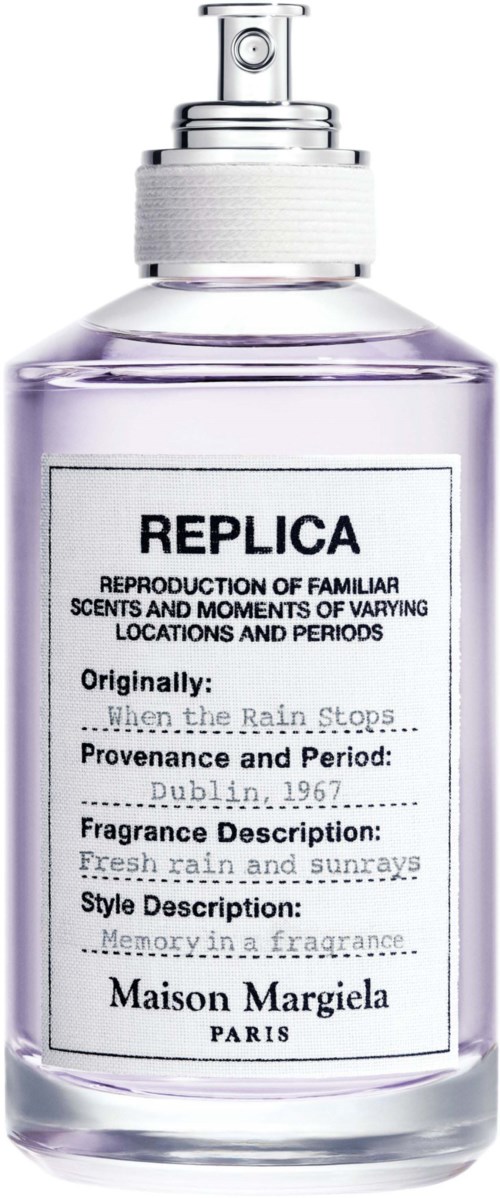Eine klare Parfüflasche mit dem Label Replica von Maison Margiela, mit Sprühkopf und beschreibendem Etikett.