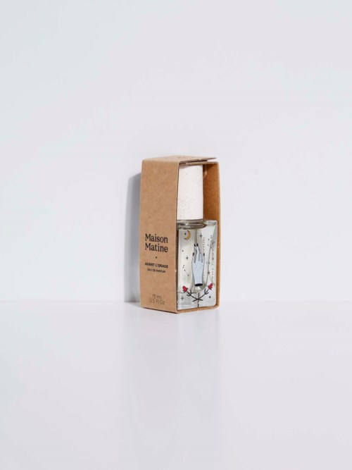 A clear glass bottle with a white spray cap inside a brown cardboard box, labeled "Maison Matine."