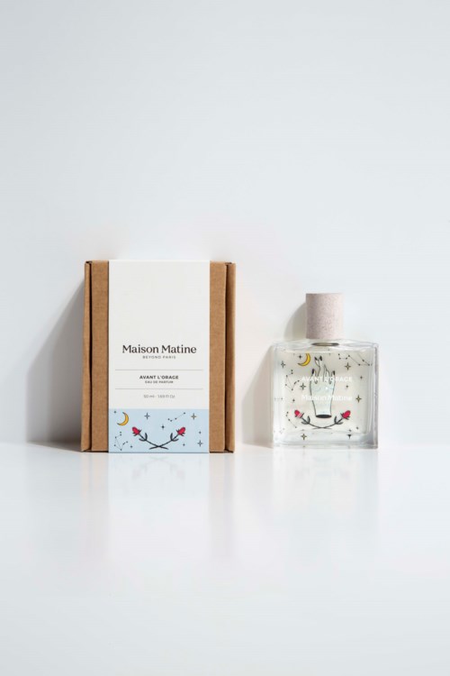 A soap box and a perfume bottle with a playful face design on the label and bottle.
