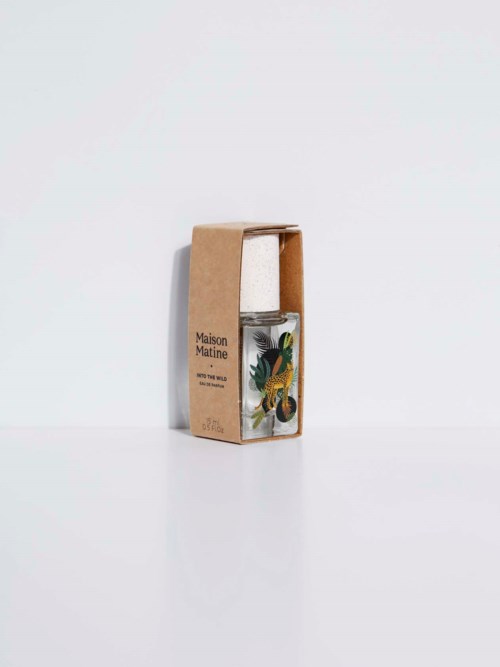 A glass bottle with a tropical plant design placed inside a brown cardboard box.