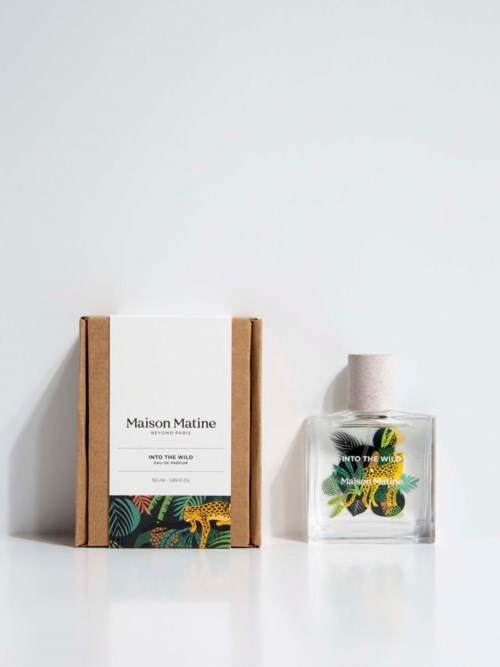 A soap bottle with a floral and leaf design and a white cap, placed next to a box with a label and colorful print.