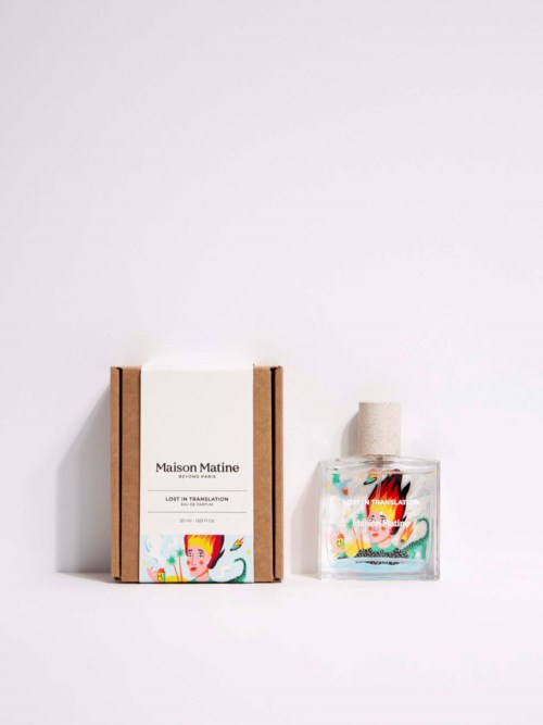 A perfume bottle and box with colorful artistic labels on a white background.
