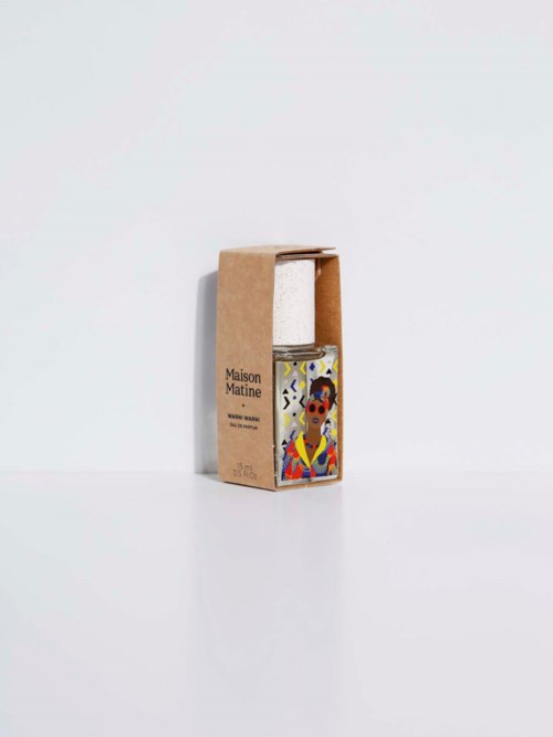 A small bottle with colorful art on front, inside a simple cardboard box, against a plain white background.