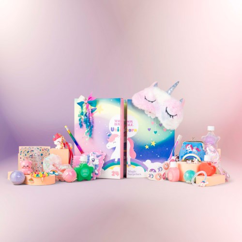 A colorful unicorn-themed gift set with plush, unicorn headband, and various small toys and beauty products.