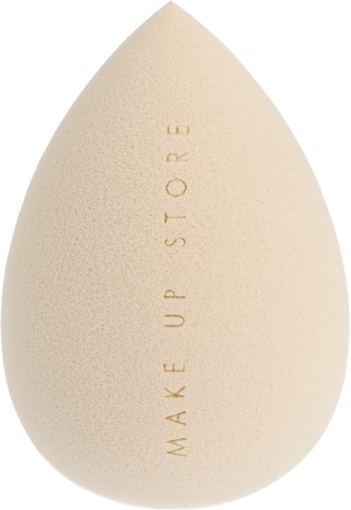 A beige blending sponge with the words 'MAKE UP STORE' engraved vertically on it.
