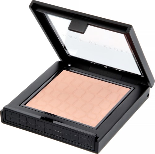En svart make-up-kompakt med spegel, innehållande peachfärgad puder med ett honungskakmönster.