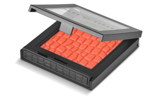 En makeup-palett med orange nyanser och ett tydligt lock öppet, visar flera ögonskuggor.