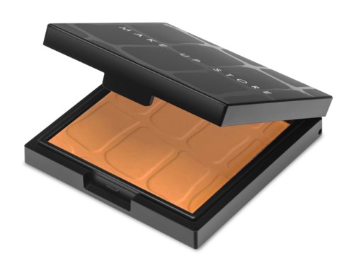 En makeupkompakt med orange puder inuti och ett svart lock som säger 'FENTY BEAUTY' på toppen.