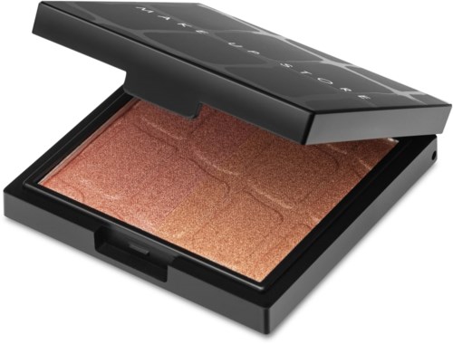En makeupprodukt i en svart kompack med spegel, skimrande brungul färg inuti, öppen lock, liten storlek.