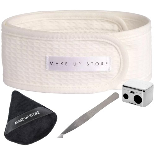 Ein weißes Stirnband, schwarze Tasche, Metallwerkzeug und kleiner Behälter für Make-up oder Beauty-Routinen.