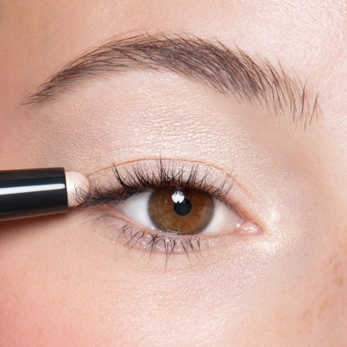 Eine Person trägt Mascara auf die oberen Wimpern auf.
