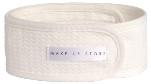 Ein weißes Stoff-Stirnband mit einem Etikett, das "MAKE UP STORE" sagt. Es ist weich und dehnbar.