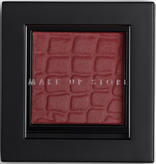 En röd panel med texturerat mönster i en svart ram, med ett delvis synligt meddelande: "MAKE UP STORE".