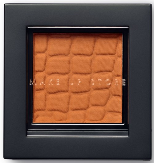 En svart ram med en texturerad orange mittendel och orden "MAKE UP STORE" i mitten.