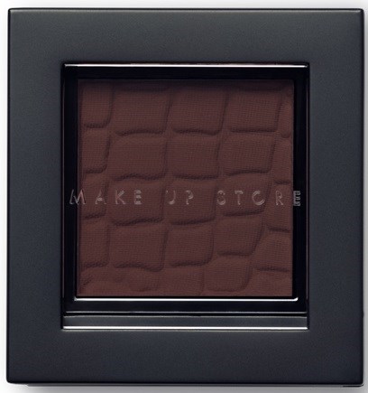 En makeup contour palette med en texturerad spegelbakgrund och nyanser av rouge och ögonskugga.