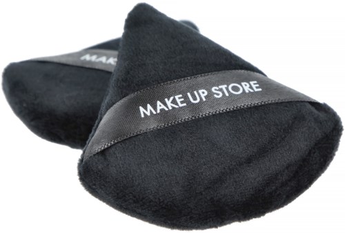 Zwei schwarze Make-up-Schwämme mit einem Etikett, das 'MAKE UP STORE' sagt, liegen auf einer Oberfläche.