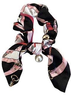 En scarf med rosa, svart och vitt, knuten med ett pärl hängande från den.